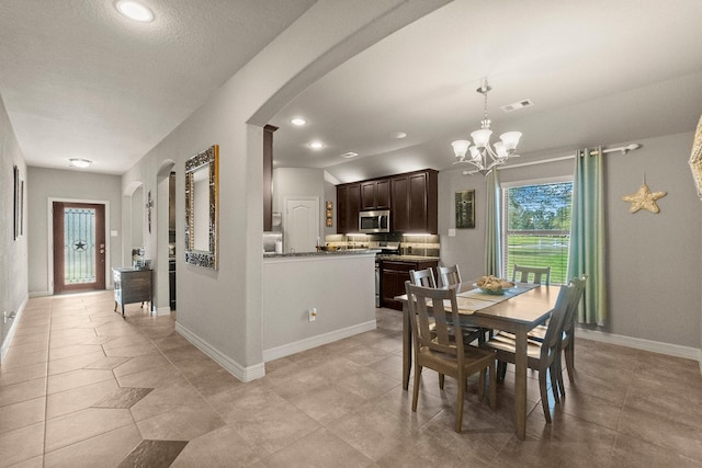 dining space featuring visible vents, a notable chandelier, recessed lighting, arched walkways, and baseboards