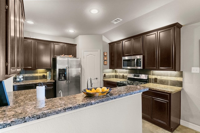 kitchen featuring tasteful backsplash, appliances with stainless steel finishes, and dark brown cabinetry