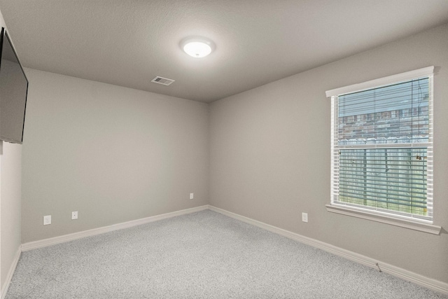 unfurnished room with carpet flooring, baseboards, and visible vents