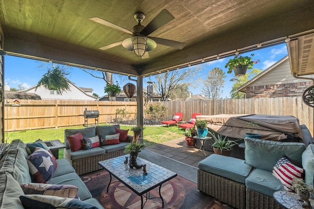 view of patio / terrace with an outdoor living space, a fenced backyard, and ceiling fan