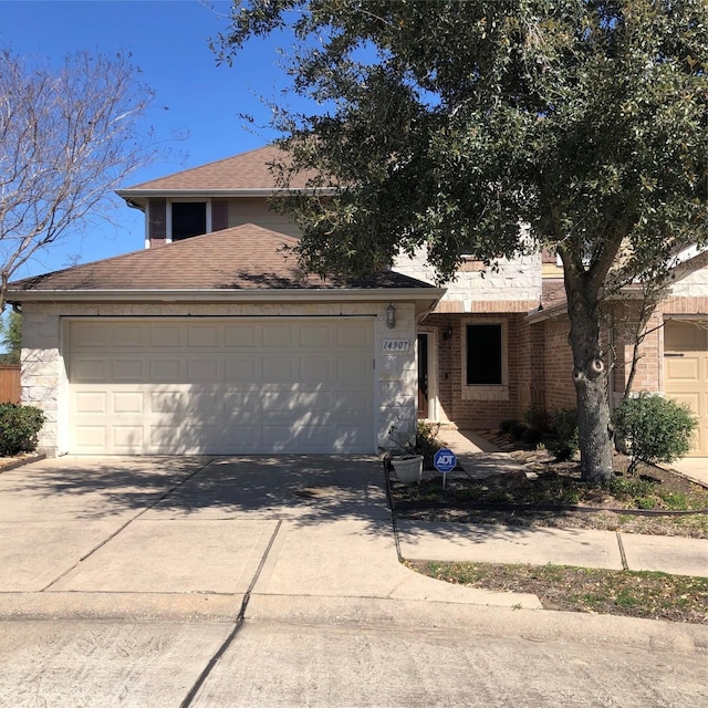 14907 Havenvale Ln, Houston, TX 77049 - view of front facade with brick siding, a garage, driveway, and a shingled roof
