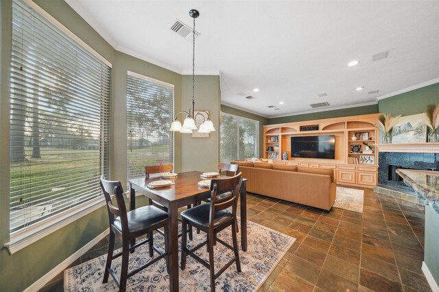 18719 Rusty Anchor Ct, Humble, TX 77346 - dining room featuring an inviting chandelier, crown molding, a fireplace with raised hearth, and baseboards