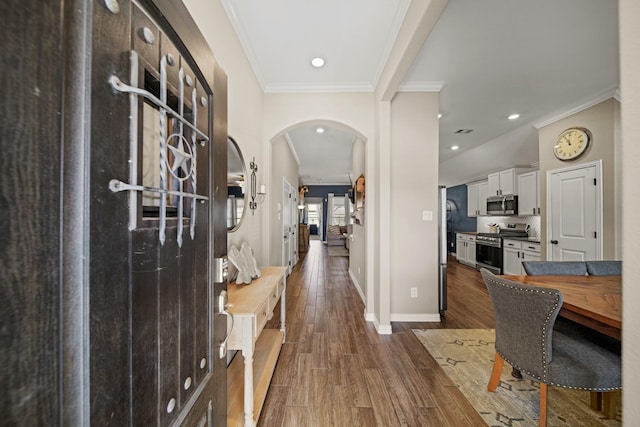 entryway with baseboards, recessed lighting, arched walkways, dark wood-style flooring, and crown molding