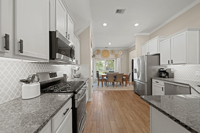 kitchen with light wood-type flooring, visible vents, appliances with stainless steel finishes, white cabinets, and crown molding