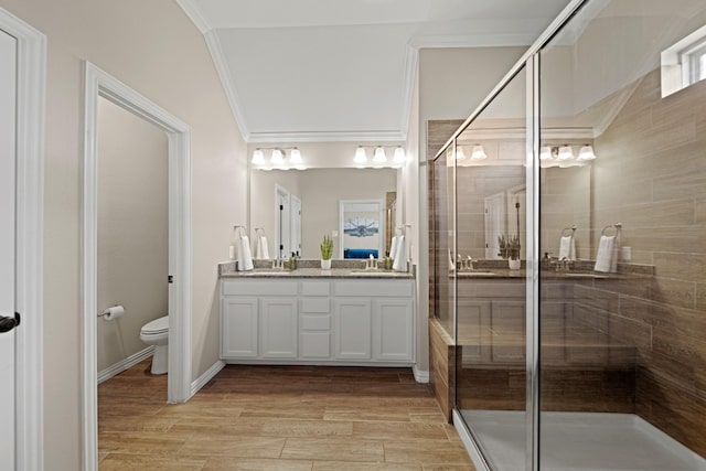 full bathroom with a stall shower, toilet, crown molding, and double vanity