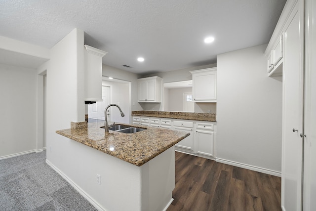 8355 Glencrest St, Houston, TX 77061 - kitchen featuring light stone countertops, white cabinetry, dark wood finished floors, a peninsula, and recessed lighting