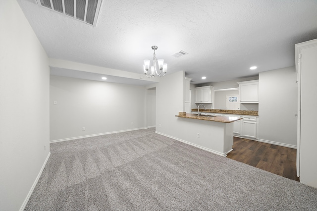 8355 Glencrest St, Houston, TX 77061 - kitchen with a chandelier, white cabinetry, recessed lighting, a textured ceiling, and pendant lighting