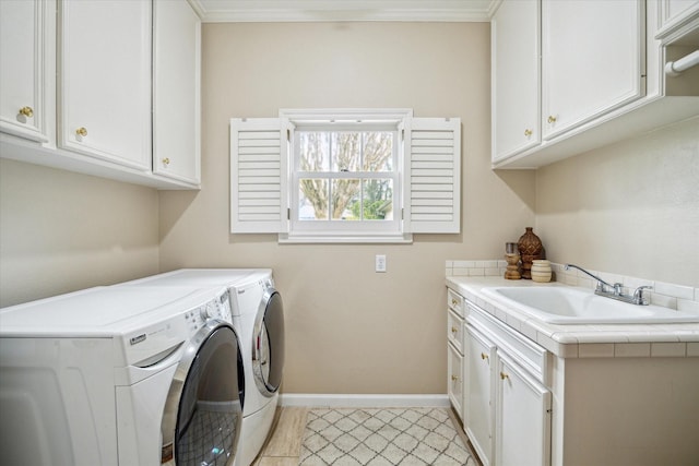 laundry room featuring baseboards, cabinet space, a sink, ornamental molding, and washer and clothes dryer