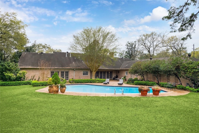 outdoor pool with a patio area and a lawn