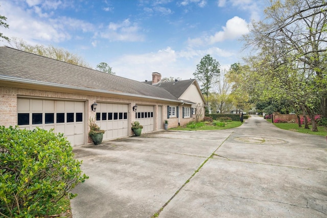 11340 Holidan Way, Piney Point Village, TX 77024 - view of side of home featuring concrete driveway, a chimney, an attached garage, brick siding, and a shingled roof