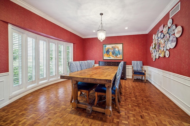 dining room featuring visible vents, ornamental molding, and a wainscoted wall