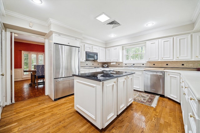 kitchen with visible vents, light wood finished floors, white cabinets, appliances with stainless steel finishes, and crown molding