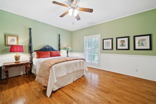 bedroom featuring wood finished floors, a ceiling fan, and ornamental molding