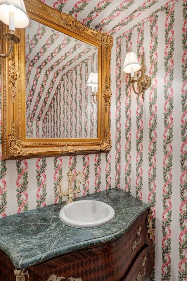 bathroom with wallpapered walls and vanity