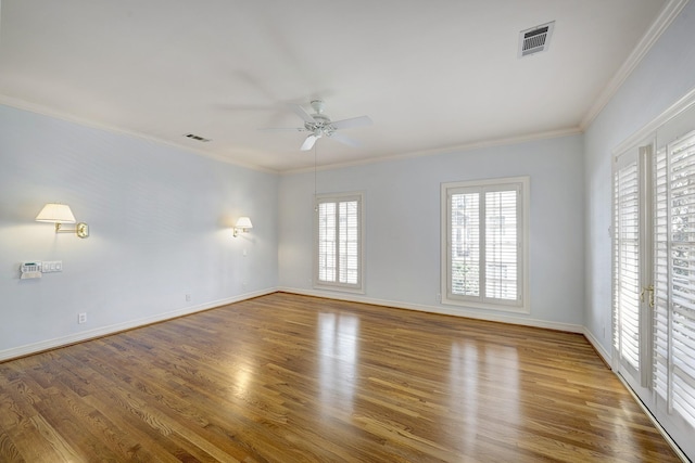 spare room featuring a ceiling fan, wood finished floors, and visible vents