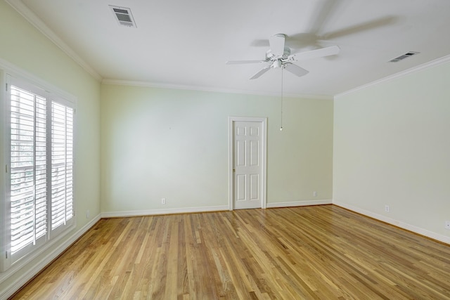 empty room featuring visible vents, light wood-style floors, crown molding, baseboards, and ceiling fan