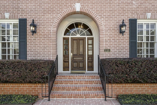 view of exterior entry featuring brick siding