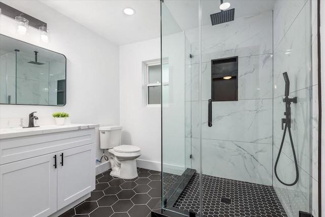 bathroom with a marble finish shower, toilet, and vanity