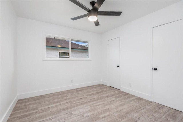 unfurnished bedroom featuring a ceiling fan, light wood-style floors, and baseboards