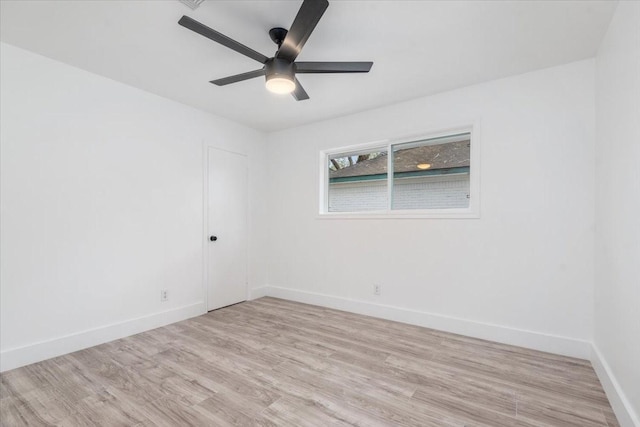 empty room featuring light wood-type flooring, baseboards, and a ceiling fan