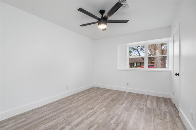 spare room featuring light wood-type flooring, baseboards, visible vents, and ceiling fan