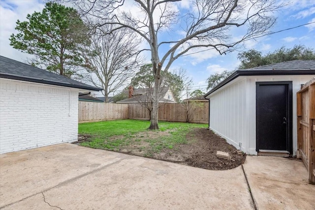 view of yard featuring a patio area, an outdoor structure, and a fenced backyard