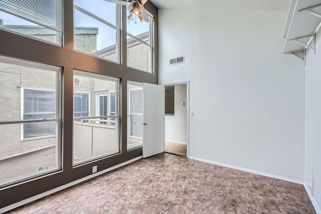 6008 Inwood Dr, Houston, TX 77057 - unfurnished living room with visible vents, baseboards, and a high ceiling