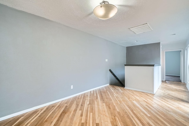 6008 Inwood Dr, Houston, TX 77057 - empty room with light wood-style floors, baseboards, and a textured ceiling