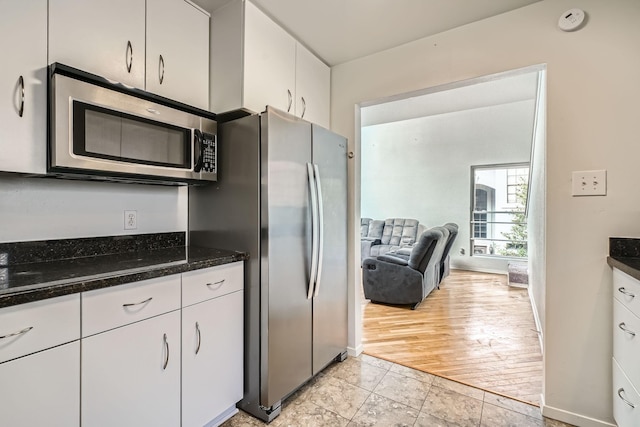 6008 Inwood Dr, Houston, TX 77057 - kitchen with dark stone counters, stainless steel appliances, and white cabinetry