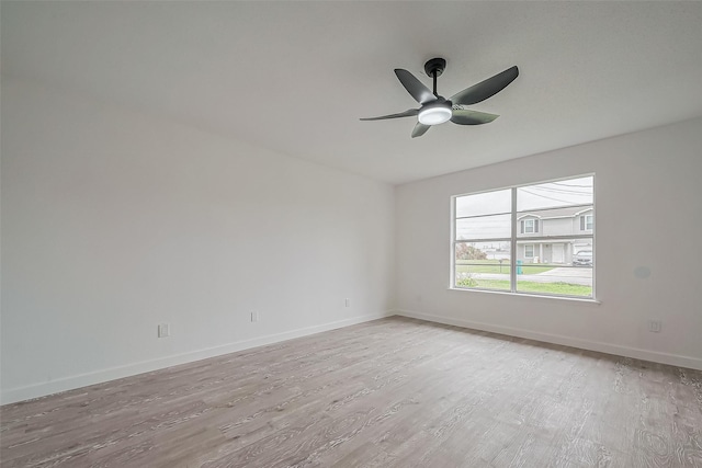 unfurnished room with baseboards, light wood-style flooring, and a ceiling fan