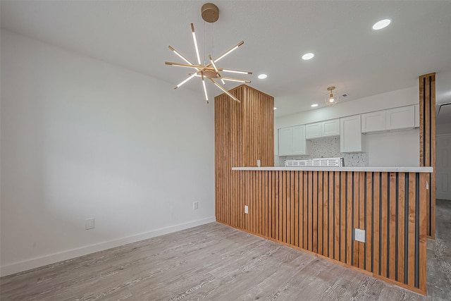 interior space with recessed lighting, baseboards, light wood-type flooring, and an inviting chandelier