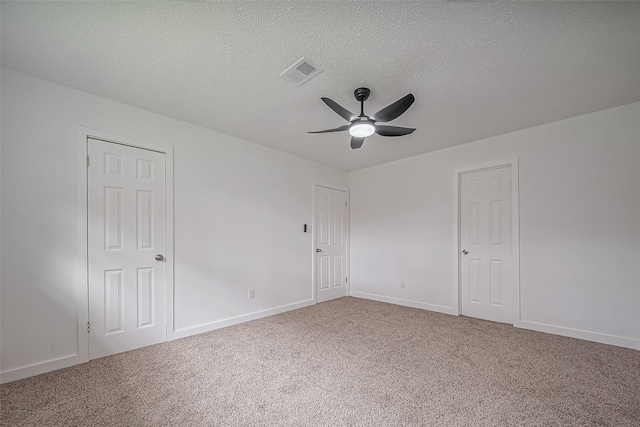 spare room featuring visible vents, baseboards, a ceiling fan, and carpet floors