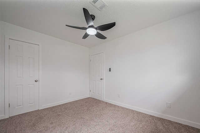 empty room featuring visible vents, baseboards, ceiling fan, carpet flooring, and a textured ceiling