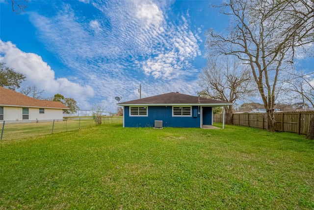 back of house featuring a fenced backyard, cooling unit, an outbuilding, and a yard