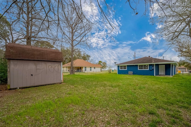 view of yard featuring a shed, an outdoor structure, and fence