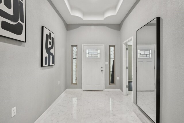 298 County Road 3545, Cleveland, TX 77327 - entryway with light marble finish floors, a tray ceiling, and baseboards