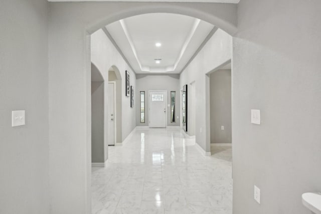 298 County Road 3545, Cleveland, TX 77327 - hall featuring arched walkways, light marble finish floors, baseboards, and a raised ceiling