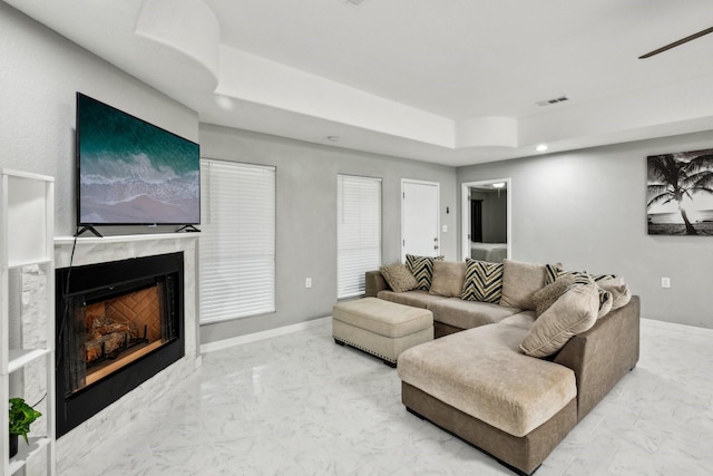 298 County Road 3545, Cleveland, TX 77327 - living room with marble finish flooring, a high end fireplace, a raised ceiling, a ceiling fan, and recessed lighting