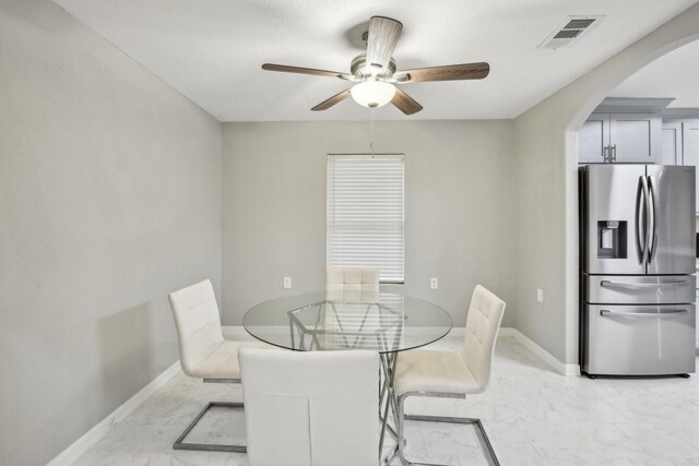 298 County Road 3545, Cleveland, TX 77327 - dining area featuring light marble finish flooring, arched walkways, a ceiling fan, and baseboards