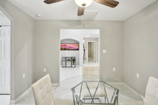 298 County Road 3545, Cleveland, TX 77327 - dining area with arched walkways, marble finish floors, ceiling fan, and baseboards