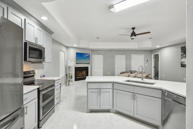 298 County Road 3545, Cleveland, TX 77327 - kitchen with stainless steel appliances, a sink, open floor plan, gray cabinets, and a tray ceiling
