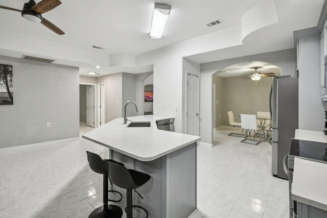 298 County Road 3545, Cleveland, TX 77327 - kitchen with a ceiling fan, arched walkways, a sink, light marble finish floors, and stainless steel appliances