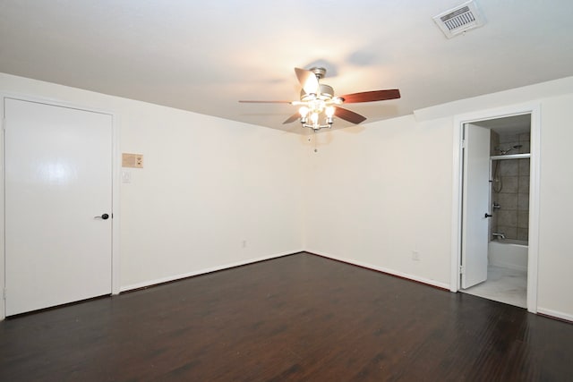 unfurnished bedroom featuring visible vents, ensuite bathroom, a ceiling fan, wood finished floors, and baseboards