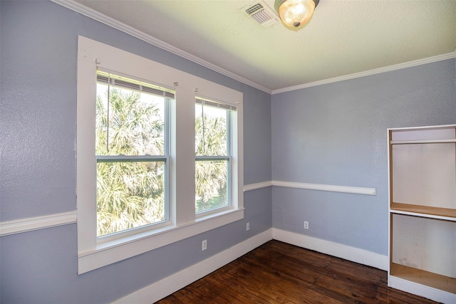 spare room featuring visible vents, baseboards, dark wood-type flooring, and crown molding