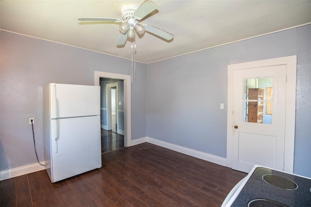 interior space with wood finished floors, a ceiling fan, baseboards, and freestanding refrigerator