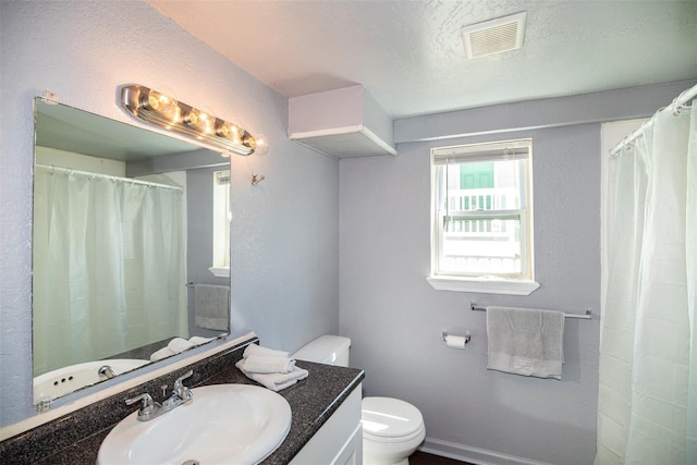 bathroom with visible vents, toilet, vanity, a shower with shower curtain, and a textured ceiling