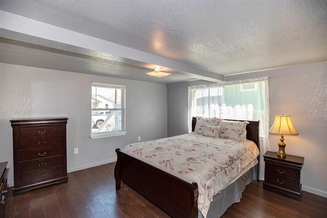 bedroom featuring a textured ceiling, dark wood-type flooring, and baseboards