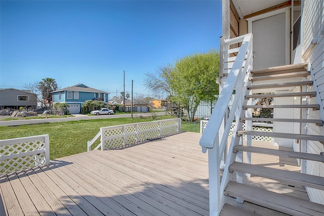 wooden terrace featuring stairway, a yard, and a residential view