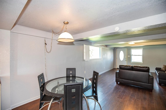 dining space featuring baseboards, a textured ceiling, and wood finished floors