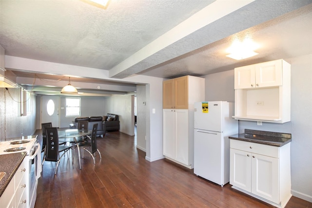 kitchen featuring white appliances, a textured ceiling, dark wood-type flooring, and baseboards